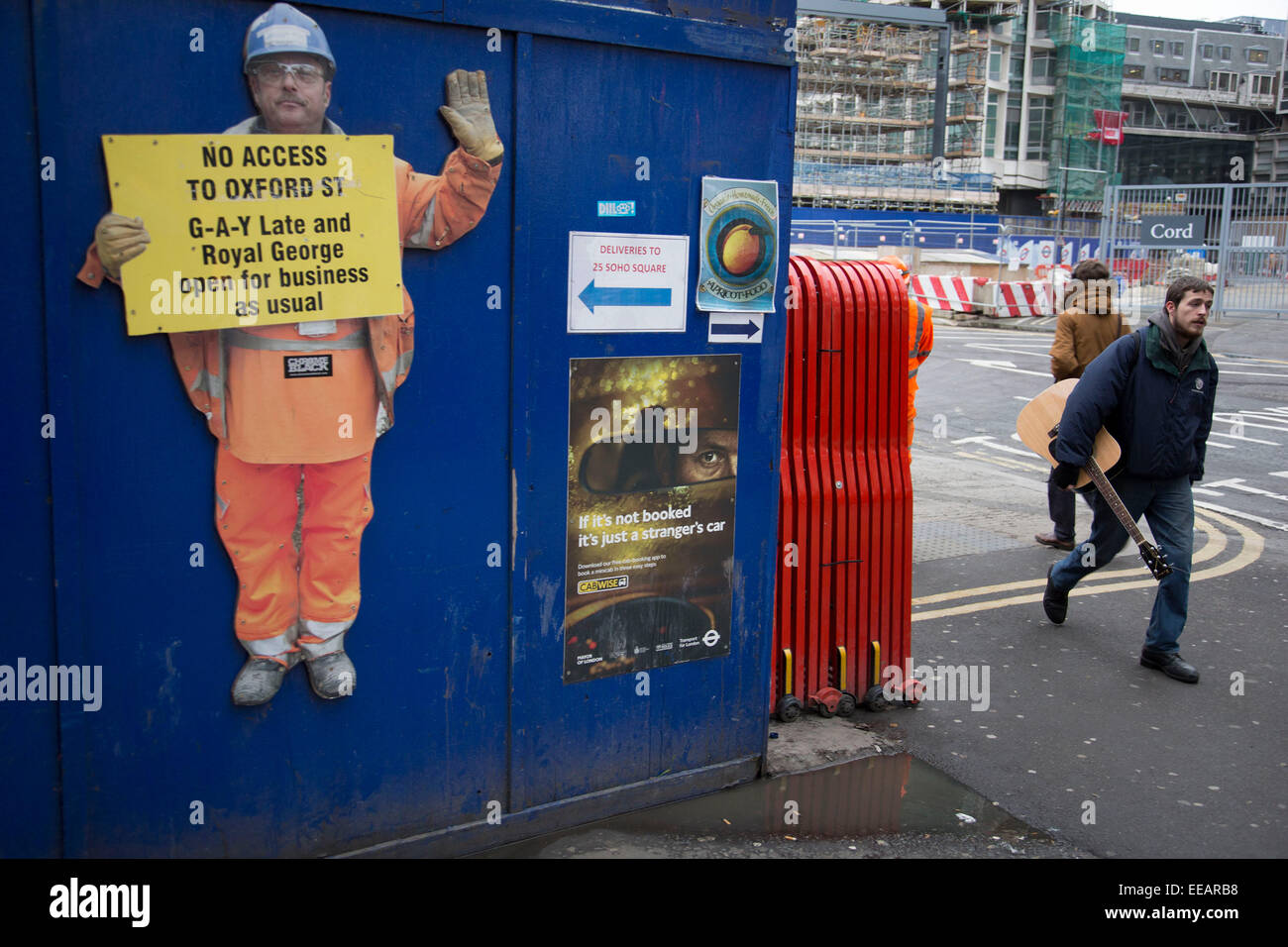 Recorte workman en el travesaño sitio de desarrollo en Tottenham Court Road, un cartel diciendo que los negocios están abiertos para los negocios como de costumbre. Incluyendo la discoteca gay. Londres, Reino Unido. Foto de stock