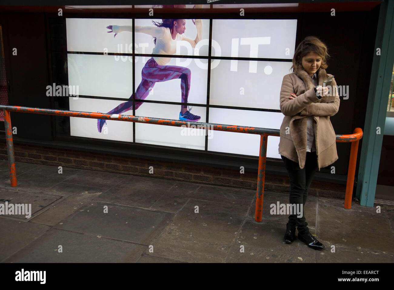 Publicidad de Nike runner recorre una barrera cerca de desprevenidas. El anuncio de vídeo con el lema do it' con mujer corriendo a través de la pantalla se convierte en