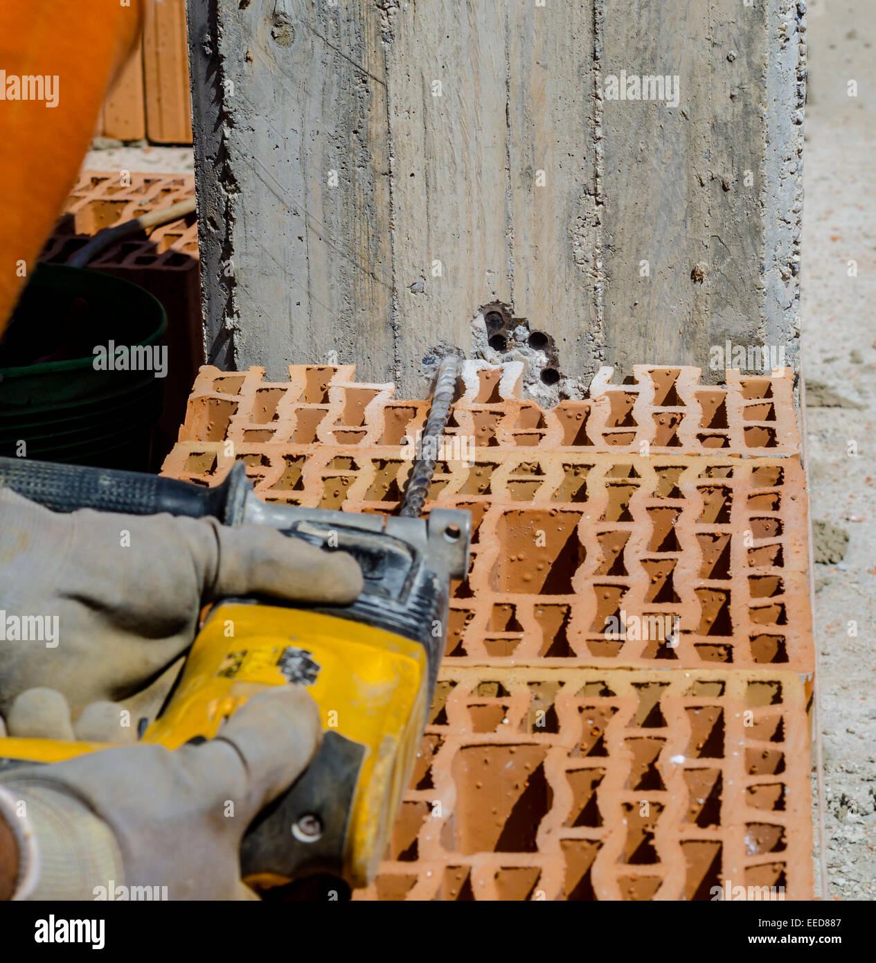 Mason taladra un orificio con un taladro en una columna de hormigón armado  Fotografía de stock - Alamy