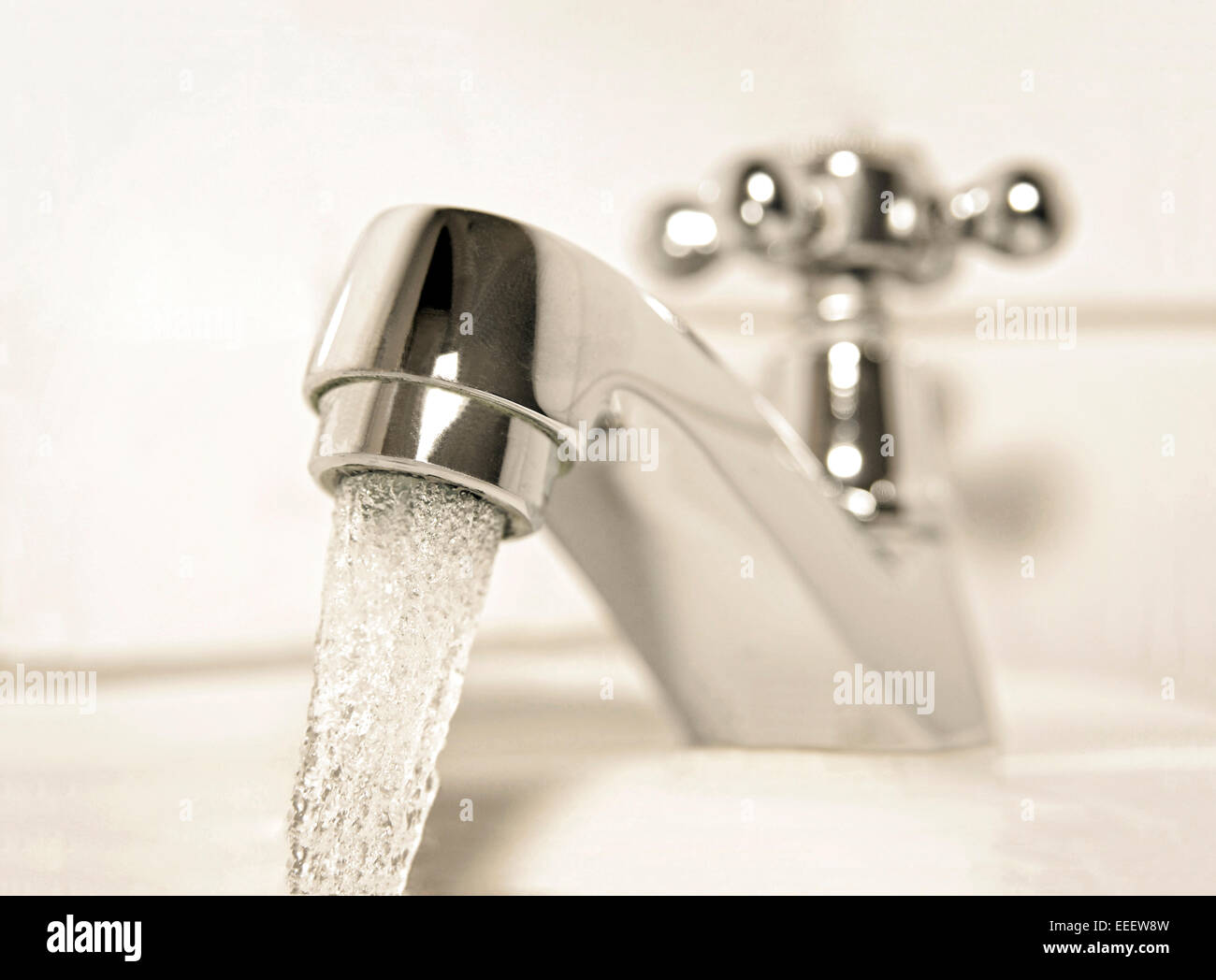 Grifo con un chorro de agua en un cuarto de baño Foto de stock