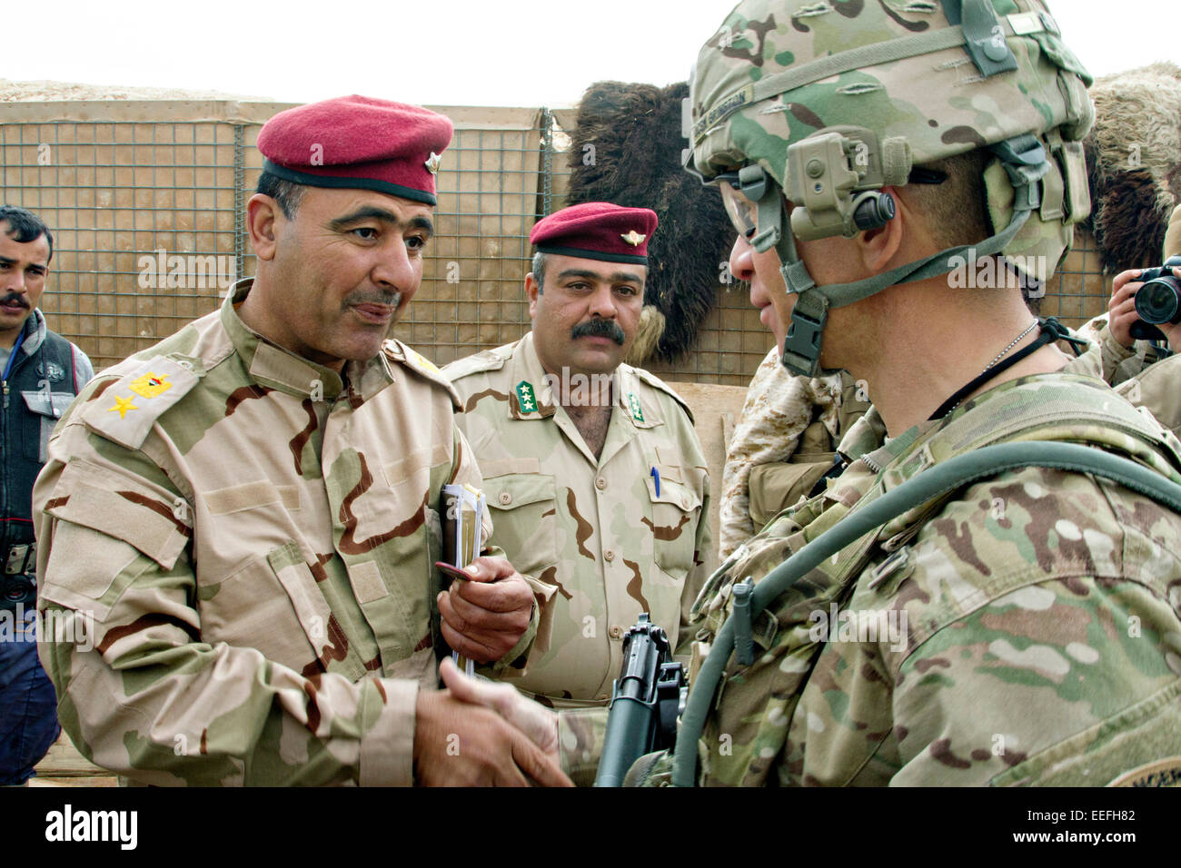 Comando del Ejército estadounidense Sgt. Gral. Michael A. Grinston un asesor de la 1ª División de Infantería, a la derecha, saluda a un oficial iraquí durante el entrenamiento de soldados del ejército iraquí de formación en la base aérea de Al Asad, 15 de enero de 2015 en Heet, Iraq. Grinston está ayudando a desarrollar el programa de formación de batallones del ejército iraquí en un esfuerzo para repeler el Estado Islámico. Foto de stock