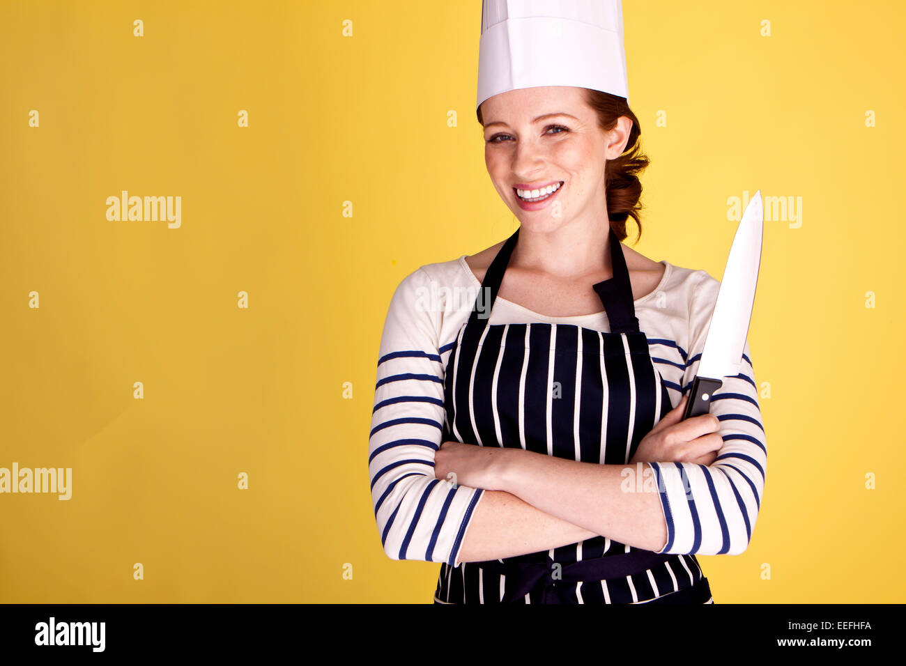 Mujer Con Gorro De Cocinero Y Delantal. Chef Profesional En Cocina. Cocina.  Mujer Feliz Cocinando Comida Saludable Por Receta. Ama De Casa Con Cuchillo  De Cocina. Copie El Espacio Mi Desayuno Favorito