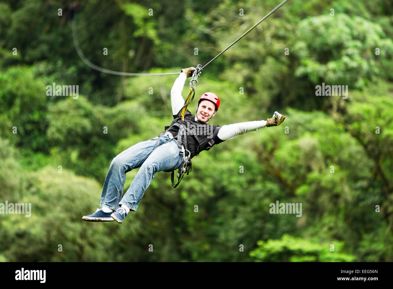 Turista adulto macho vistiendo ropa informal En Zip Line Canopy o experiencia en la Selva Ecuatoriana Foto de stock