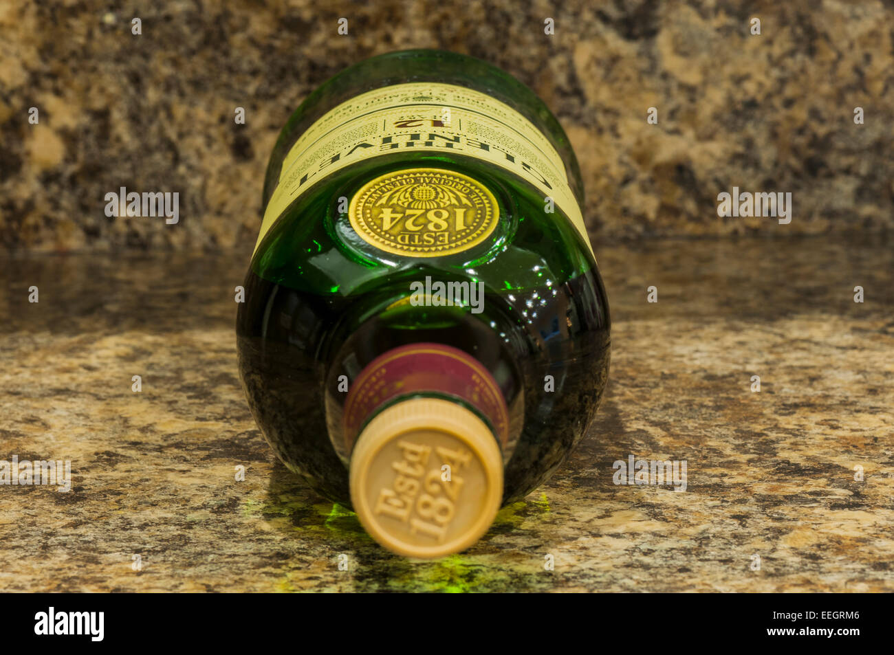 Una macro fotografía de un whisky botella acostada de lado sobre una superficie de trabajo Foto de stock