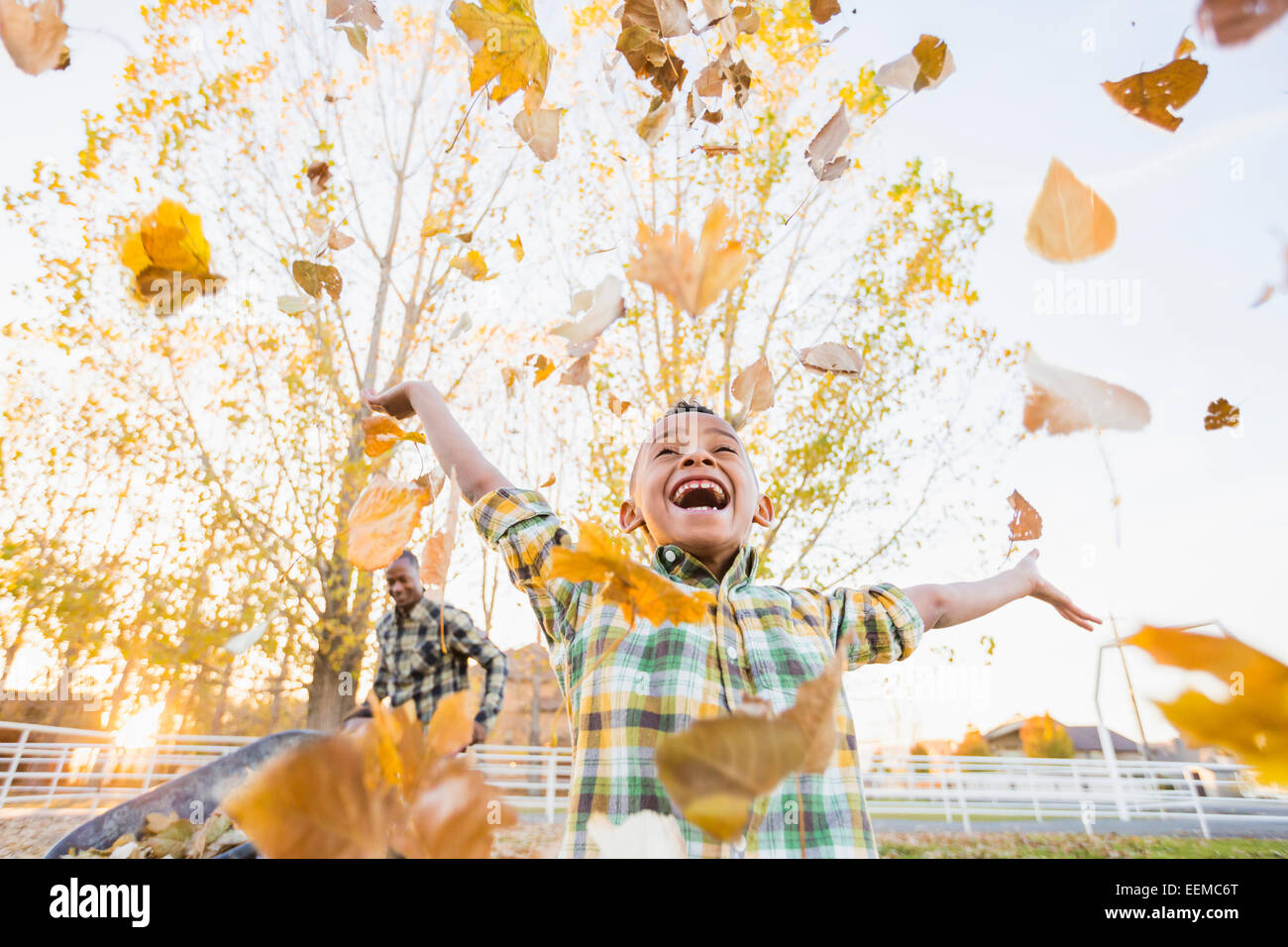 Niño jugando en hojas de otoño Foto de stock