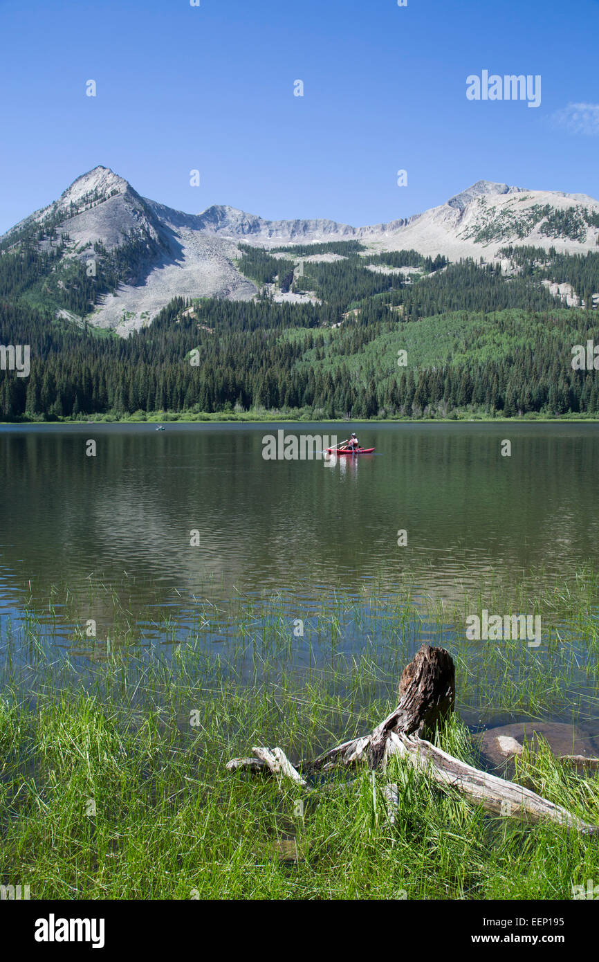 El hombre en el Pontoon Boat, Hidden Lake, Colorado, EE.UU. Foto de stock