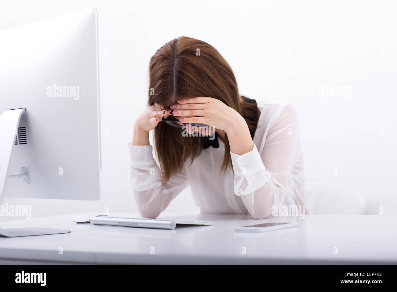 Cansada mujer de negocios sentada en su lugar de trabajo en la oficina Foto de stock