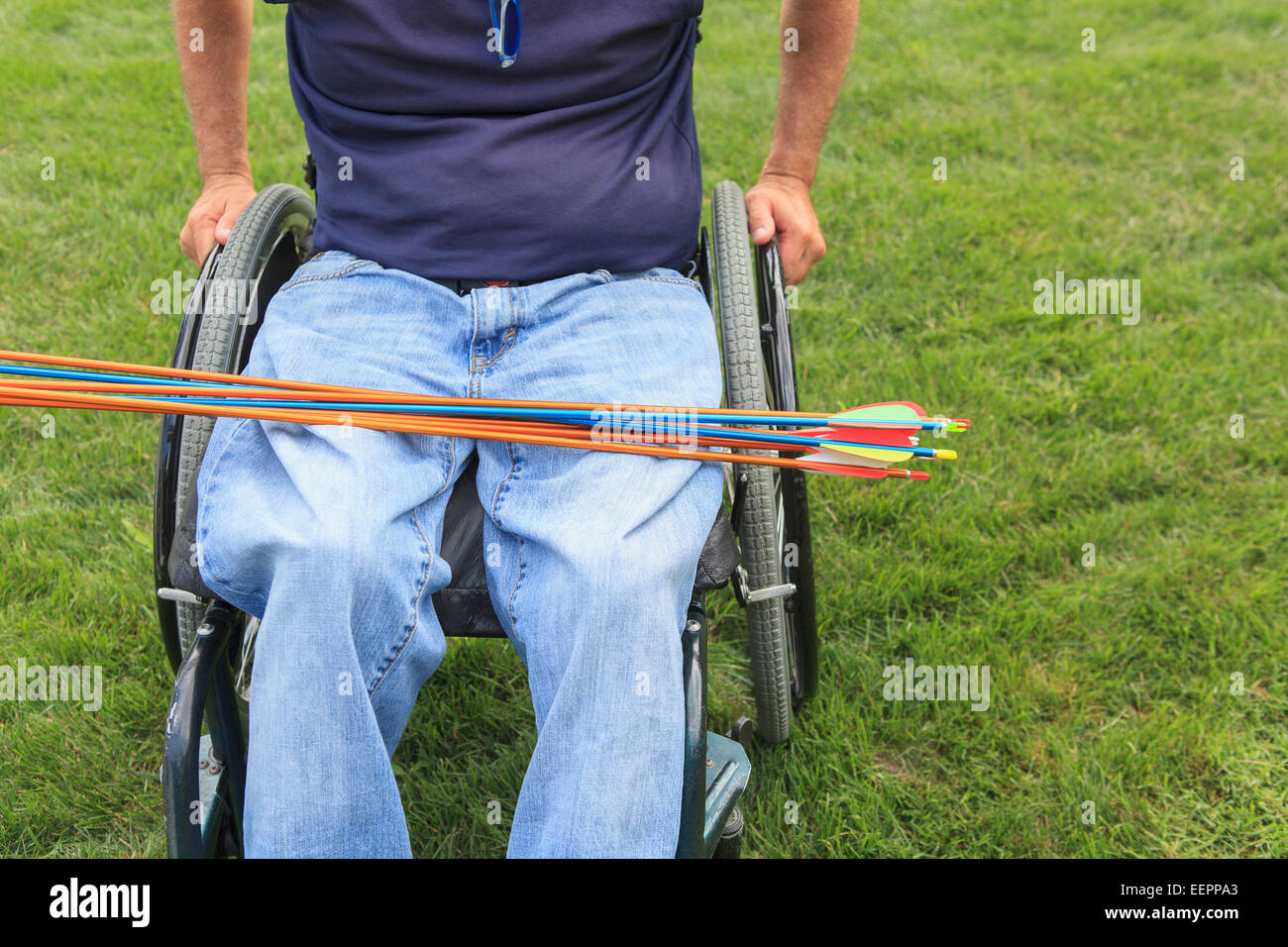 Hombre con lesión de la médula espinal en silla de ruedas se preparan para la práctica de tiro con arco Foto de stock