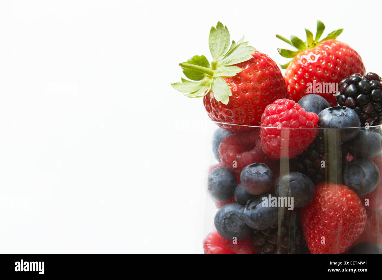 Selección de frutas de verano en vidrio contra el fondo blanco. Foto de stock