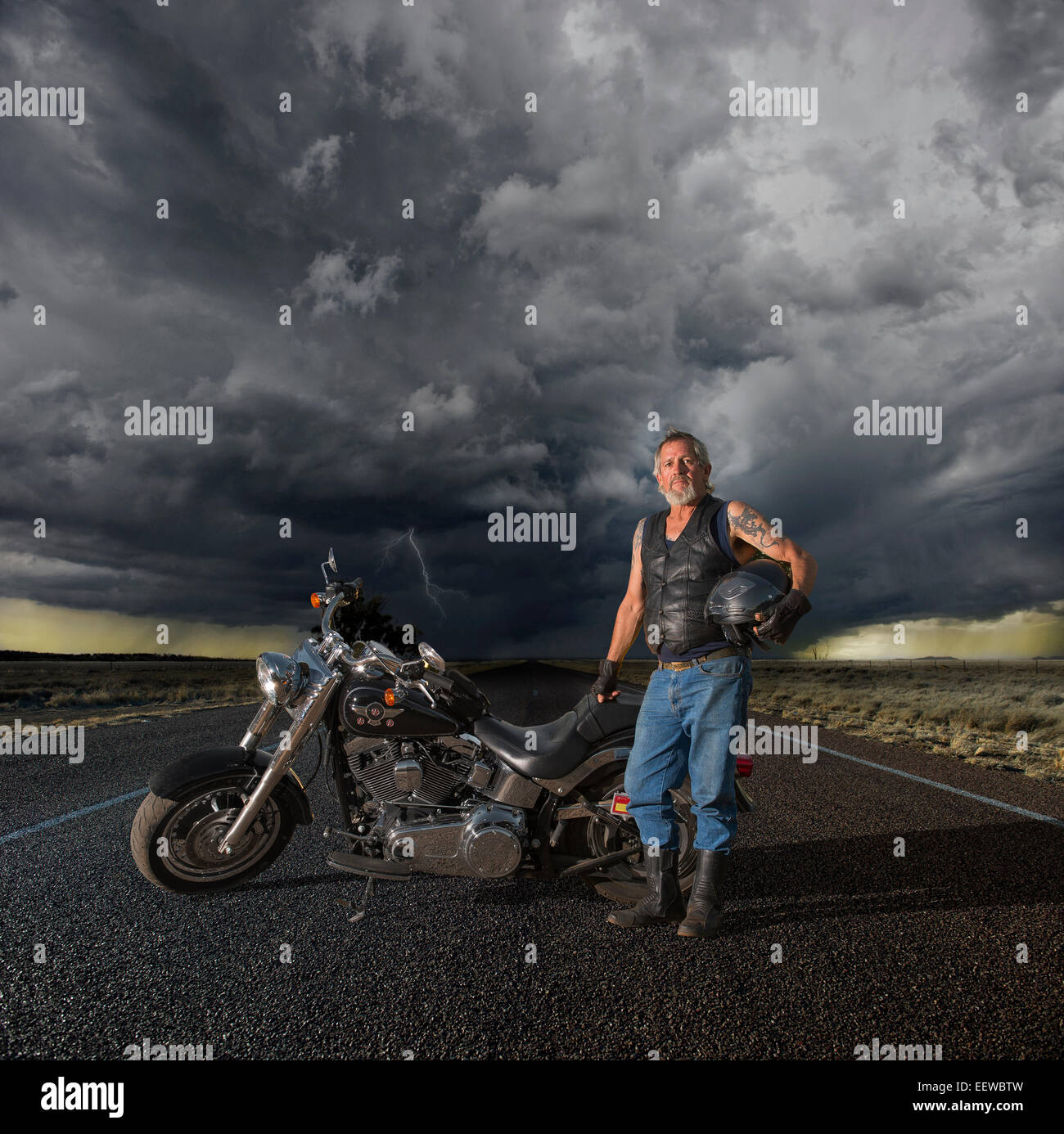 Antiguo ciclista en un largo camino con nubes de tormenta Foto de stock