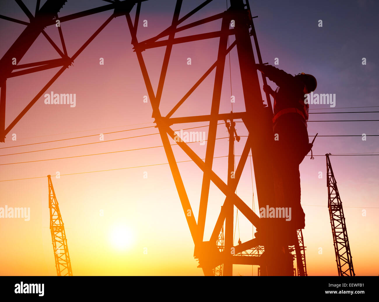 Trabajador en una subestación eléctrica con sunset antecedentes Foto de stock