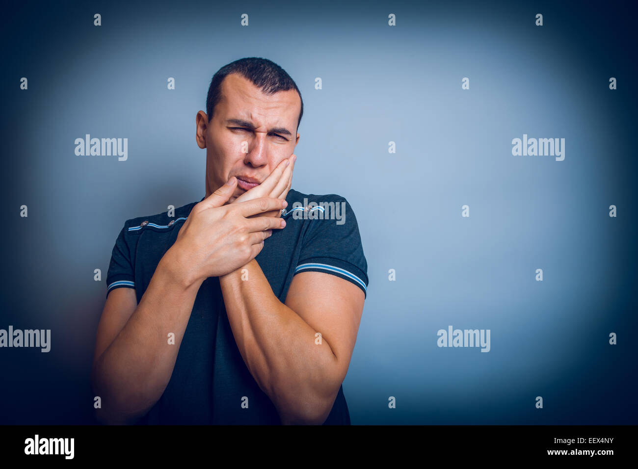 Hombre de apariencia europea brunet sostiene con la mano en la cara Foto de stock