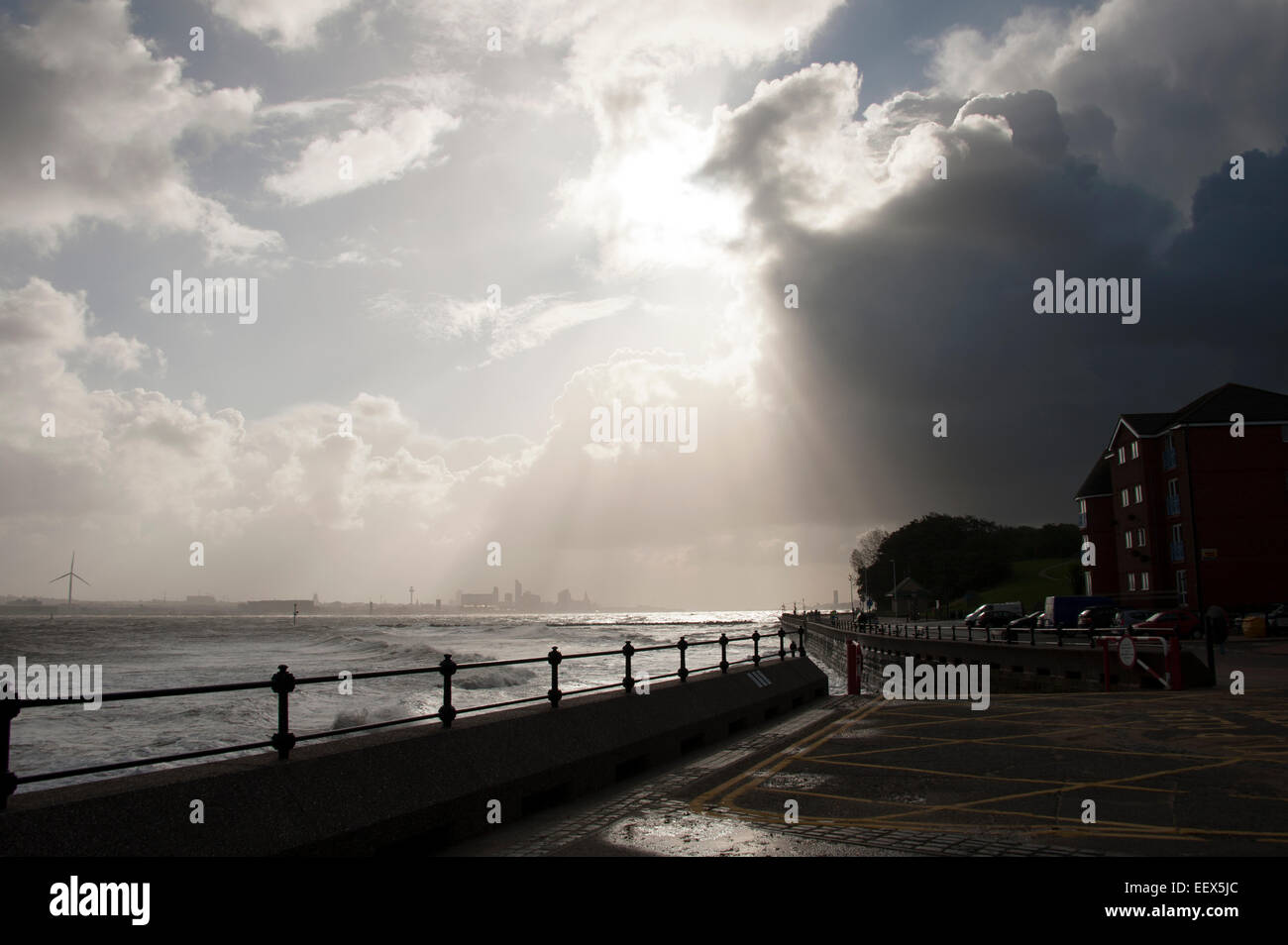 Sun rompiendo nubes ominosas Liverpool UK Foto de stock
