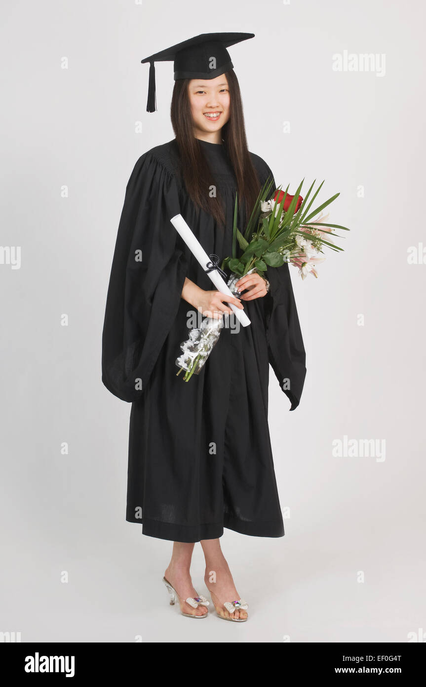 Mujer joven vistiendo una toga y birrete de graduación Fotografía de stock  - Alamy