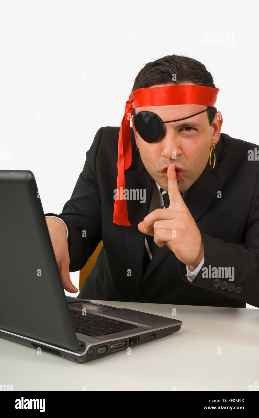 Hombre vestido como pirata escribiendo en el ordenador portátil Foto de stock