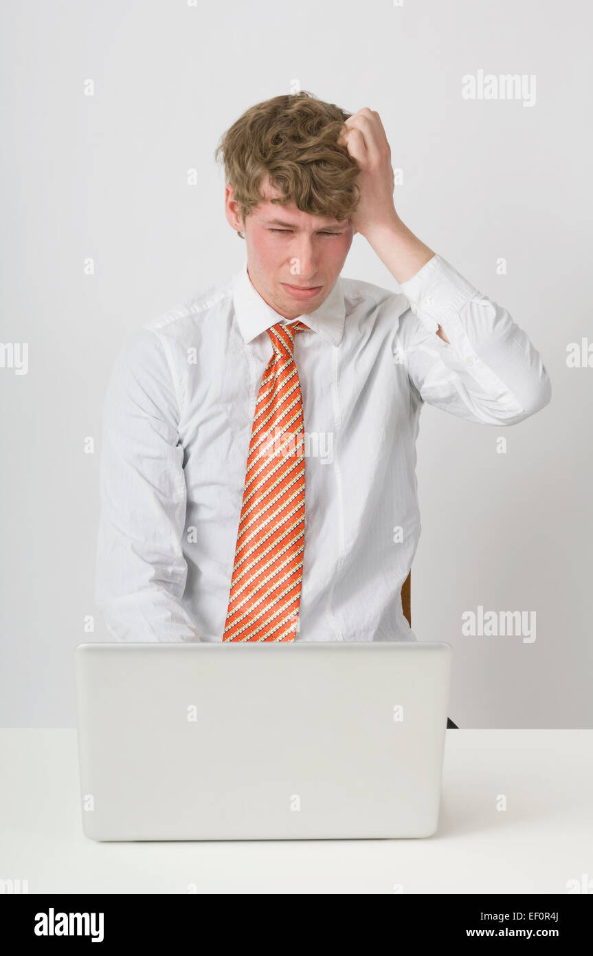 Frustrado hombre trabajando con un portátil Foto de stock