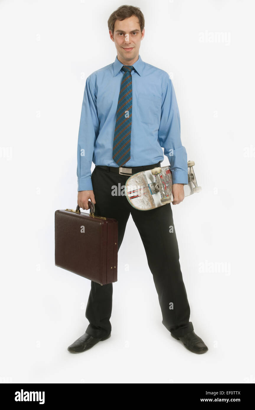 Empresario sosteniendo el monopatín y el maletín Foto de stock