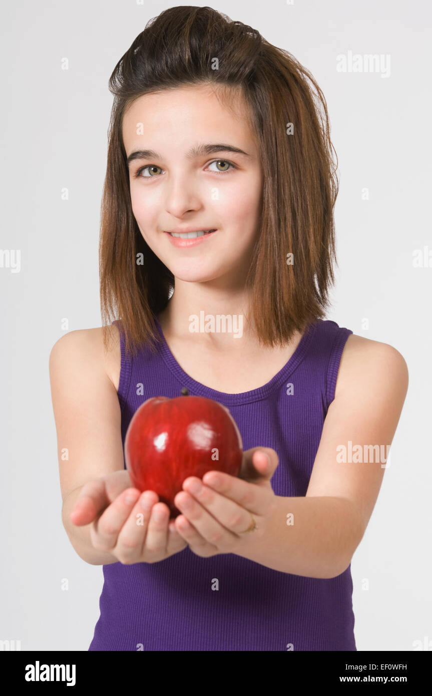 Joven Chica sujetando una manzana Foto de stock