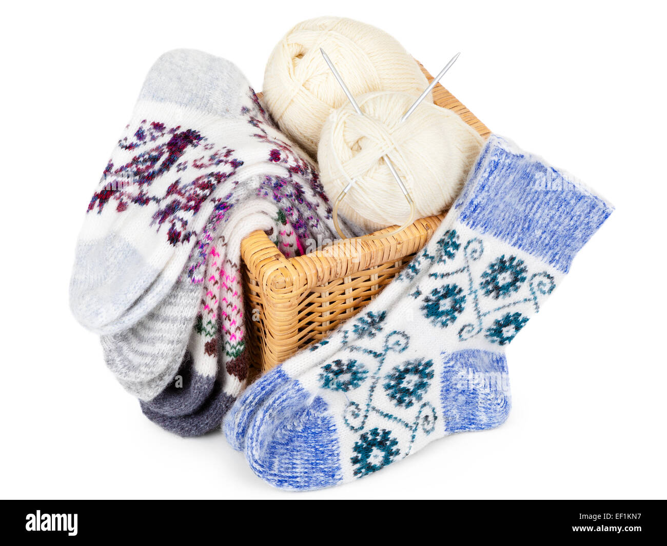 Calcetines tejidos, cesta y bolas de hilo con agujas de tejer Foto de stock
