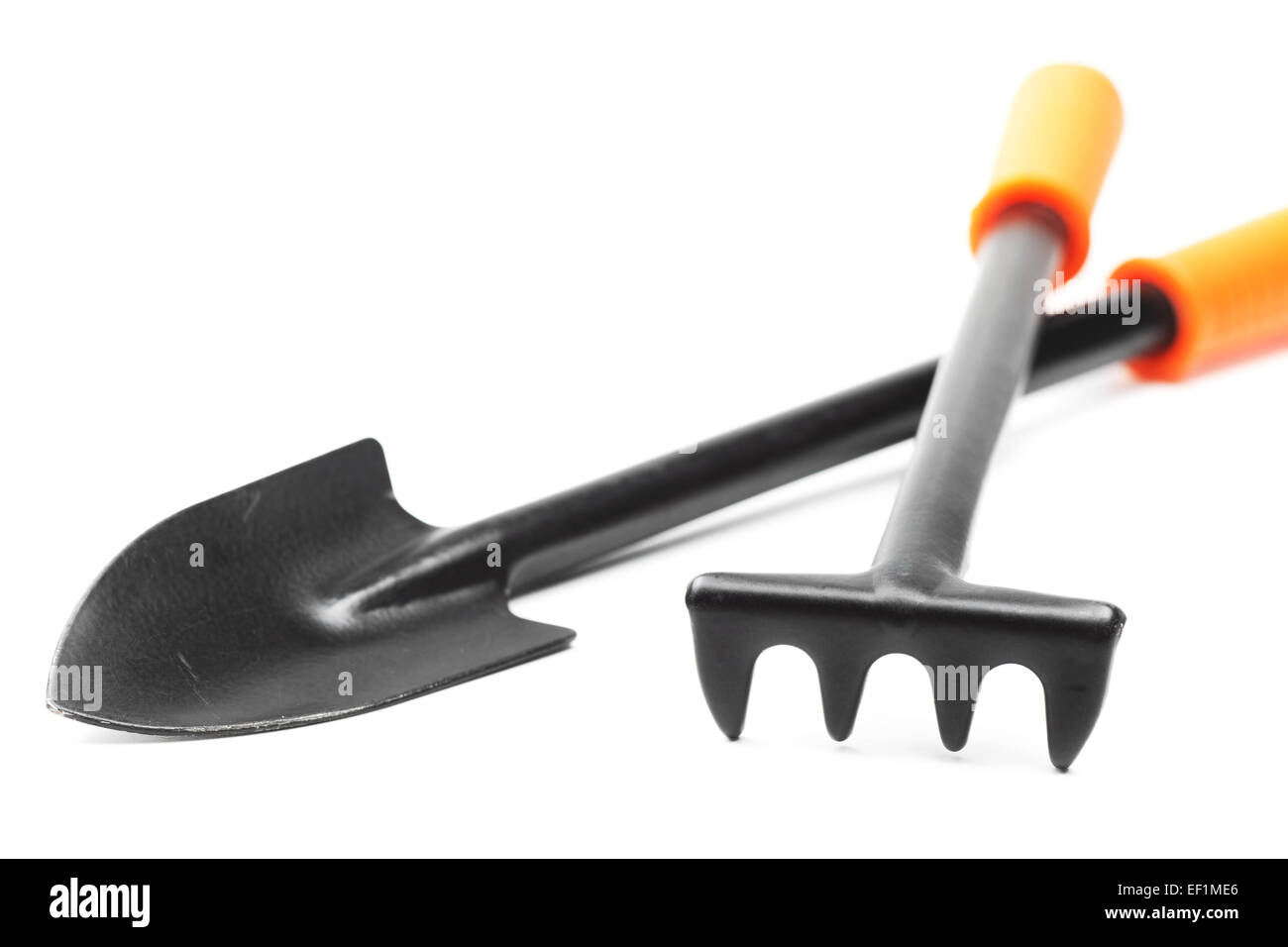 Pequeño jardín herramientas: una pala y un rastrillo sobre blanco Foto de stock