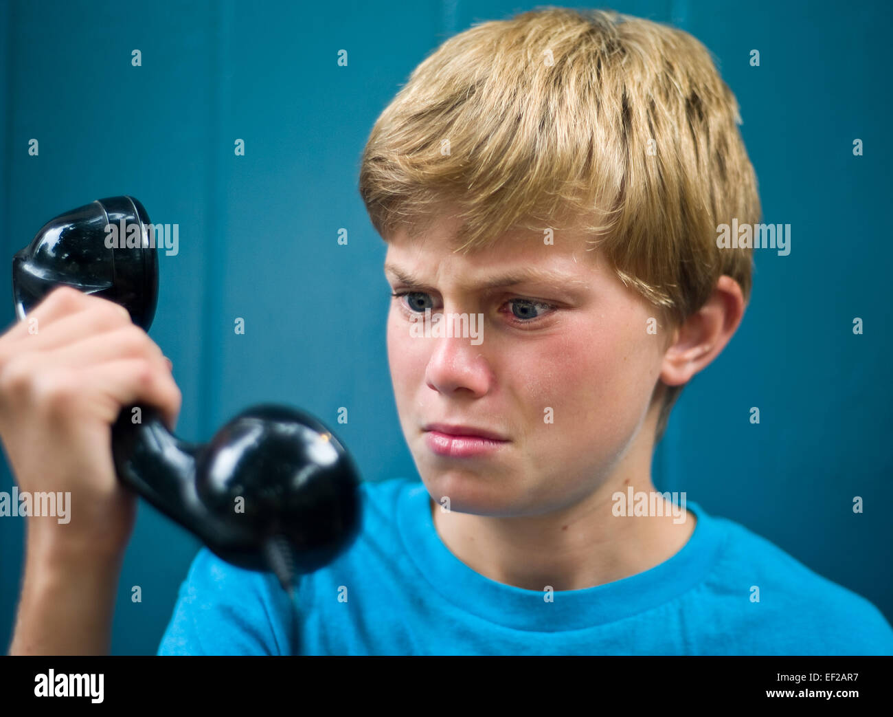 Niño infeliz en el teléfono. El estrés en el trabajo, malas noticias. Foto de stock