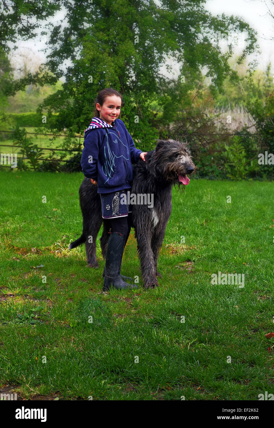 Una joven chica irlandesa con su familia pet Wolfhound irlandés en su jardín en Irlanda Foto de stock