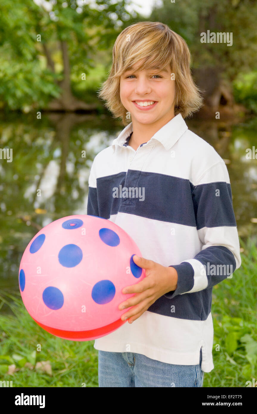 Joven sosteniendo un balón de playa Foto de stock