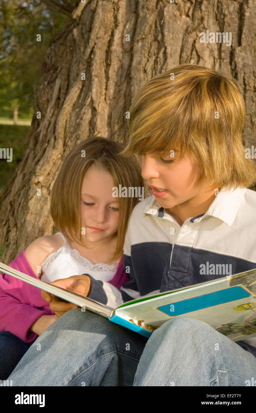 Hermano libro de lectura para Little Sister en estacionamiento Foto de stock