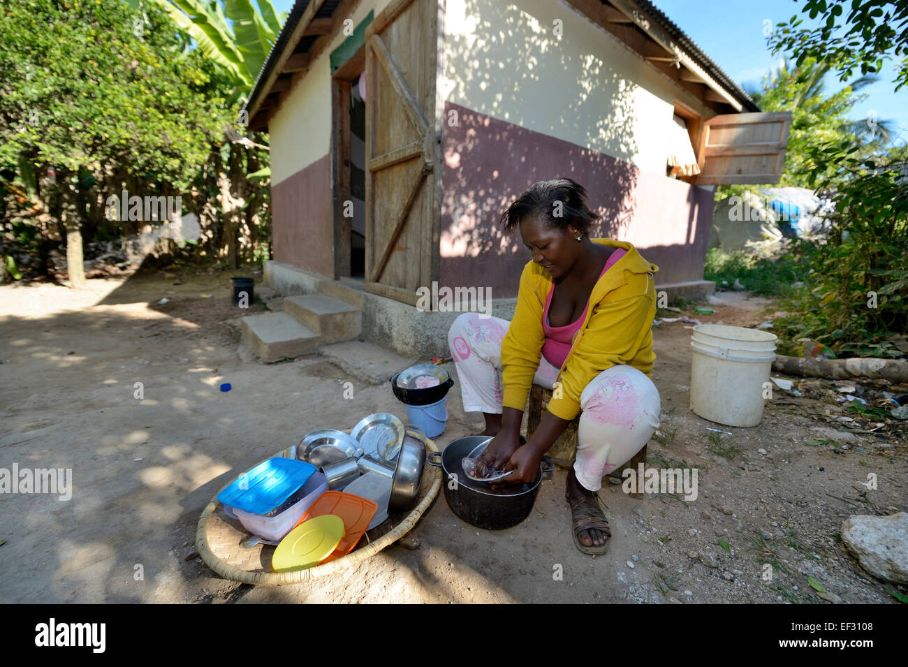 Mujer joven lavando la ropa en frente de la casa, que fue dada a la familia  por parte de una organización de socorro, Ridore, La Vallee Fotografía de  stock - Alamy