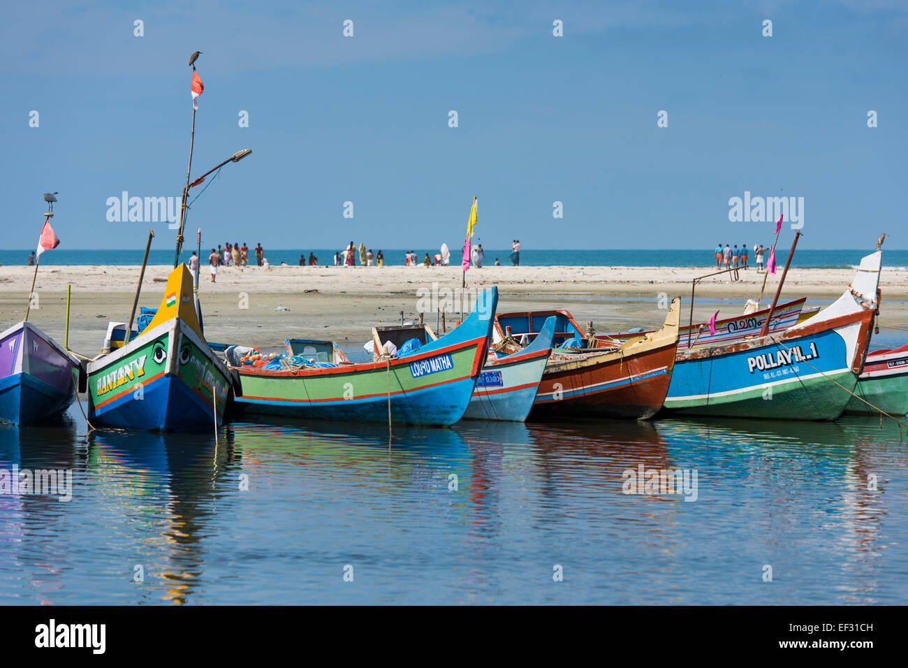 Pintadas barcas de pesca y gente en la playa, cerca de Alappuzha, Kerala, India Foto de stock