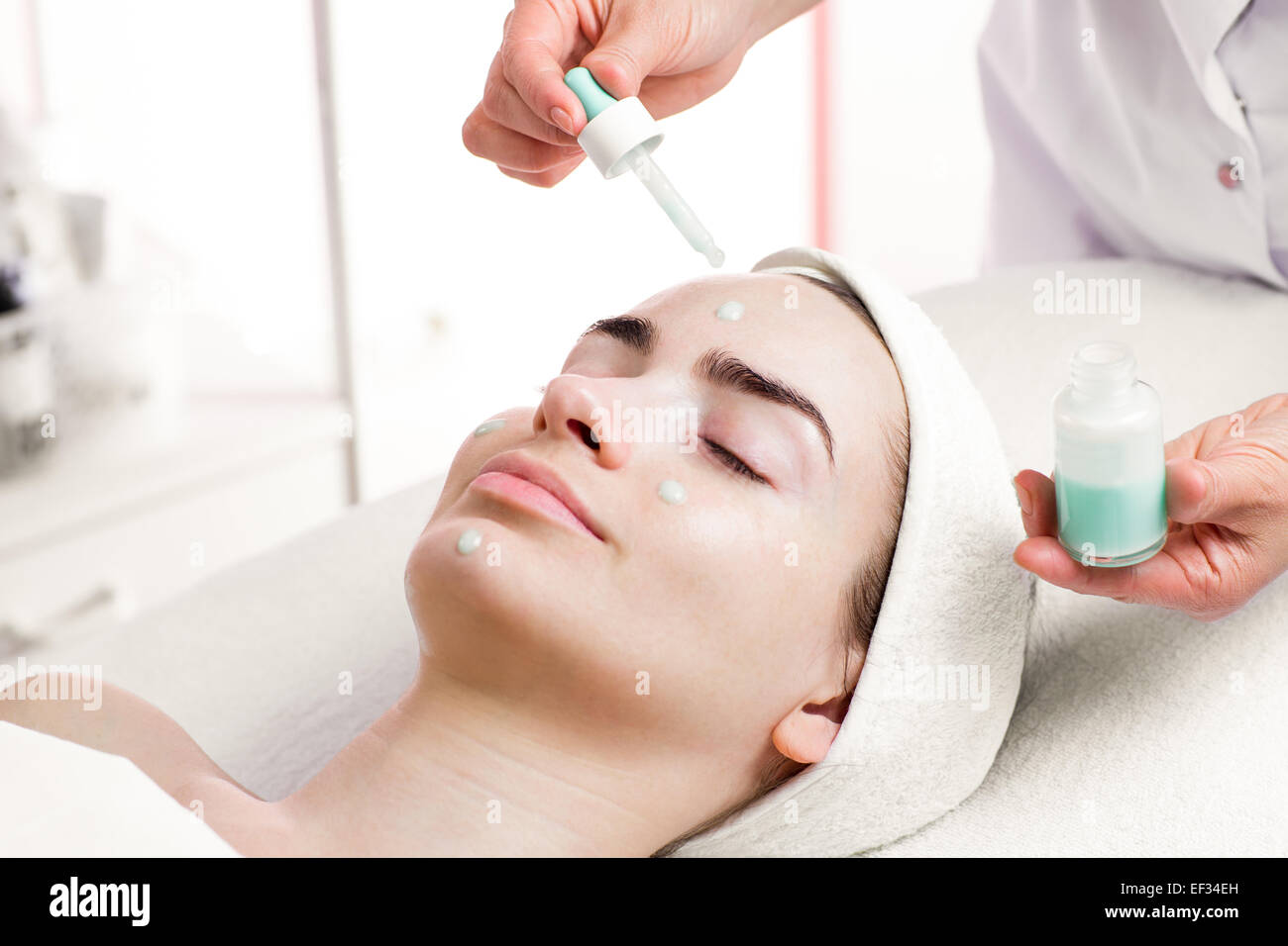 Suero tratamiento facial de la mujer joven en el salón spa Foto de stock