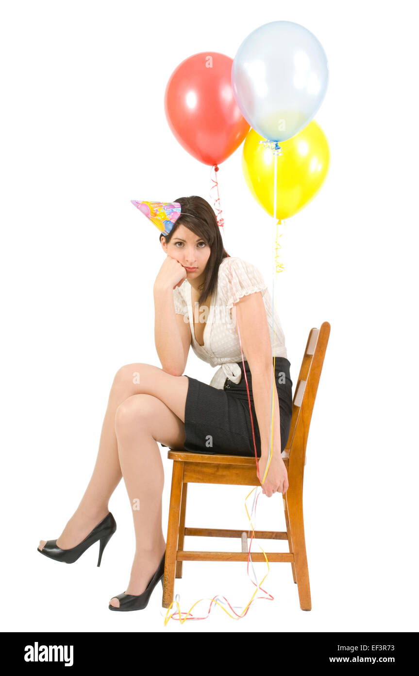 Mujer vistiendo gorro de fiesta y celebración globos Foto de stock