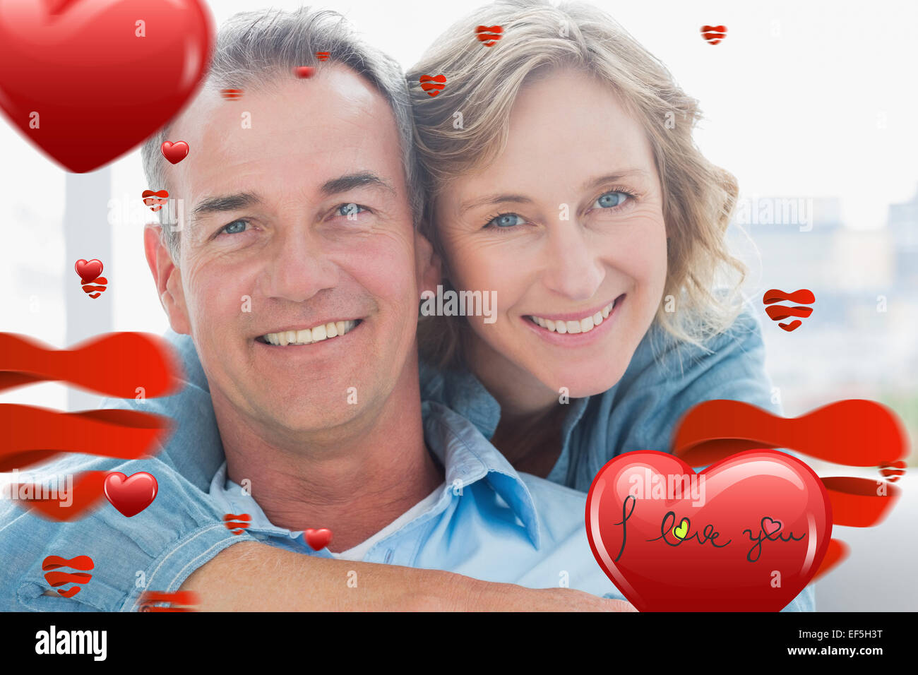Imagen compuesta de mujer sonriente abrazando a su marido en el sofá desde atrás Foto de stock
