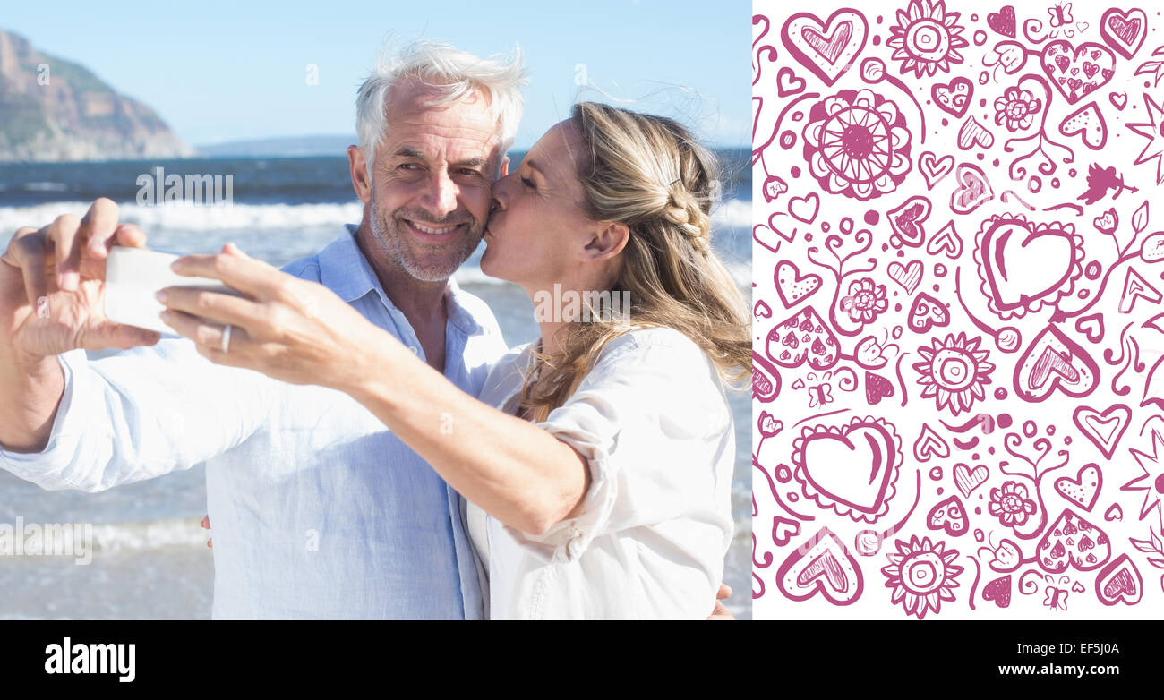 Imagen compuesta de pareja casada en la playa juntos tomando un selfie Foto de stock