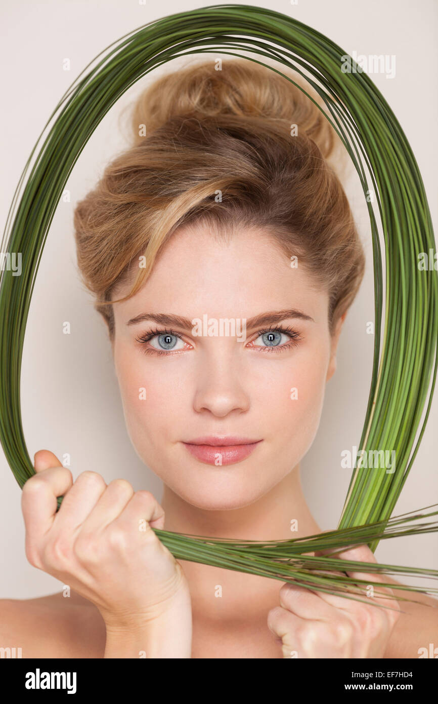 Retrato de una hermosa mujer sosteniendo wheatgrass Foto de stock