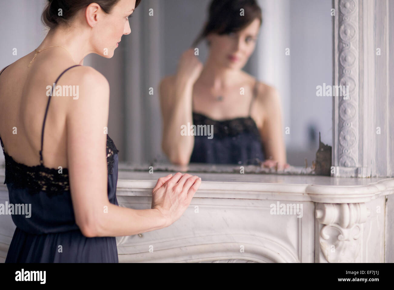 La reflexión de una mujer en el espejo Foto de stock