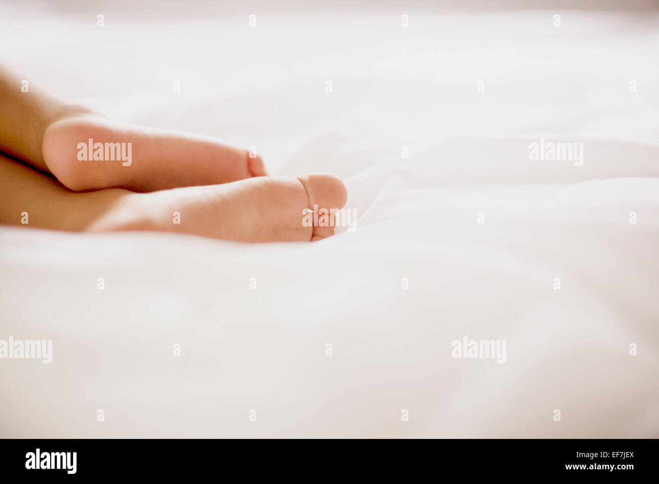 Los pies humanos en la cama Foto de stock