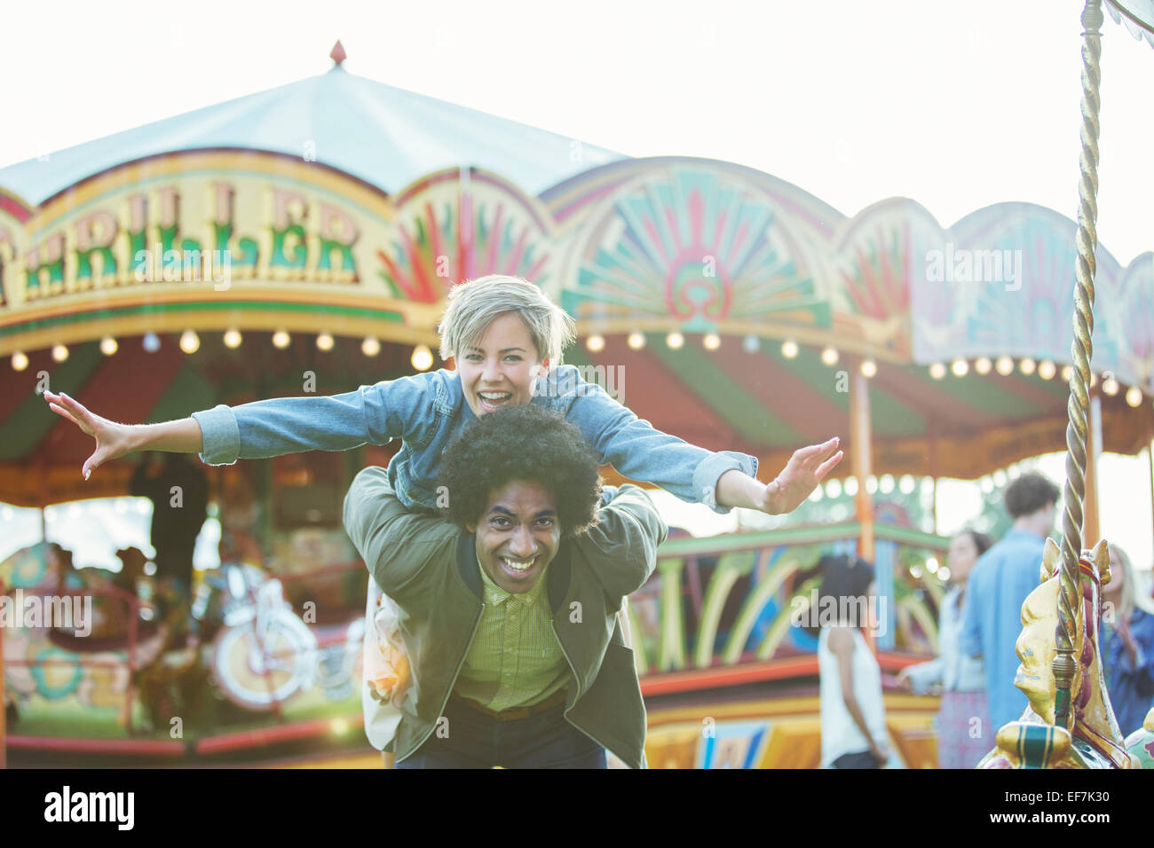 Retrato de la joven pareja multirracial a divertirse en el parque de diversiones Foto de stock