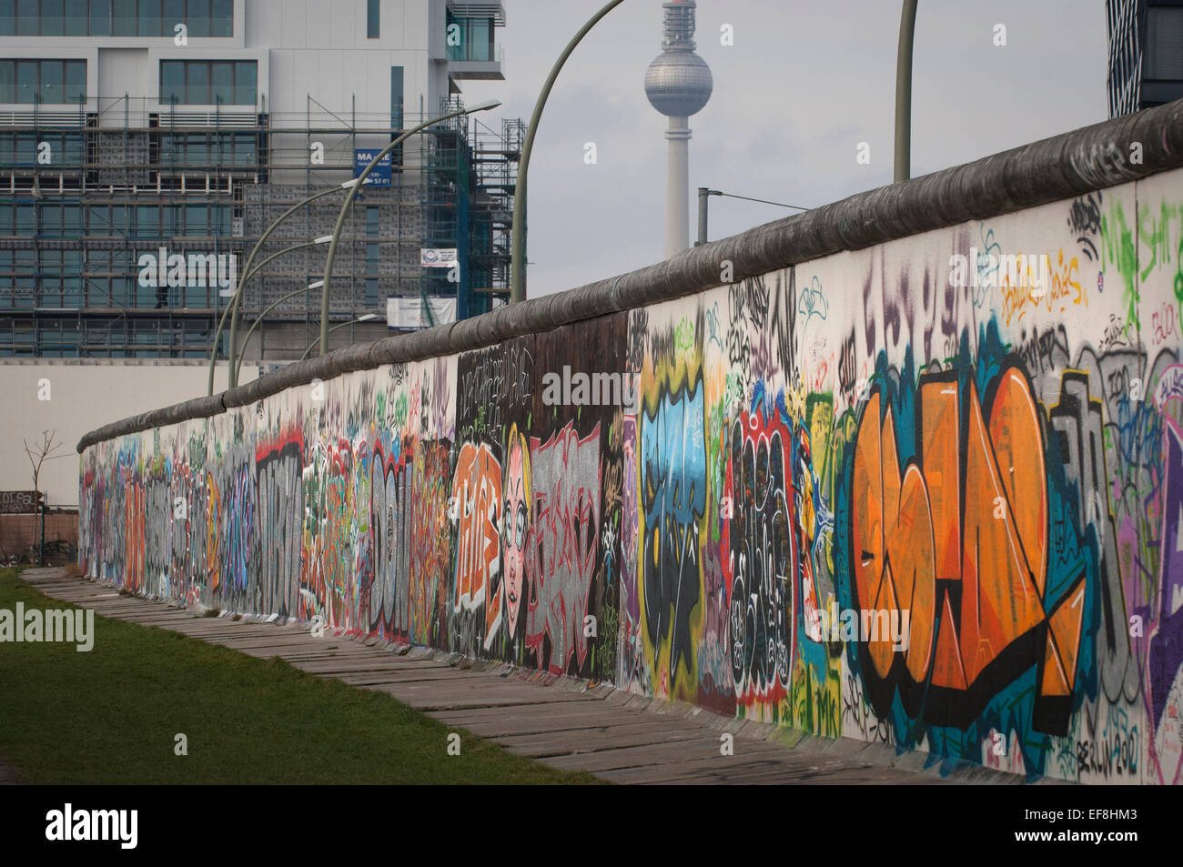 Torre de Televisión de Berlín vistos desde lo que queda del Muro de Berlín en el East Side Gallery,Mühlenstraße en Friedrichshain-Kreuzberg. Foto de stock