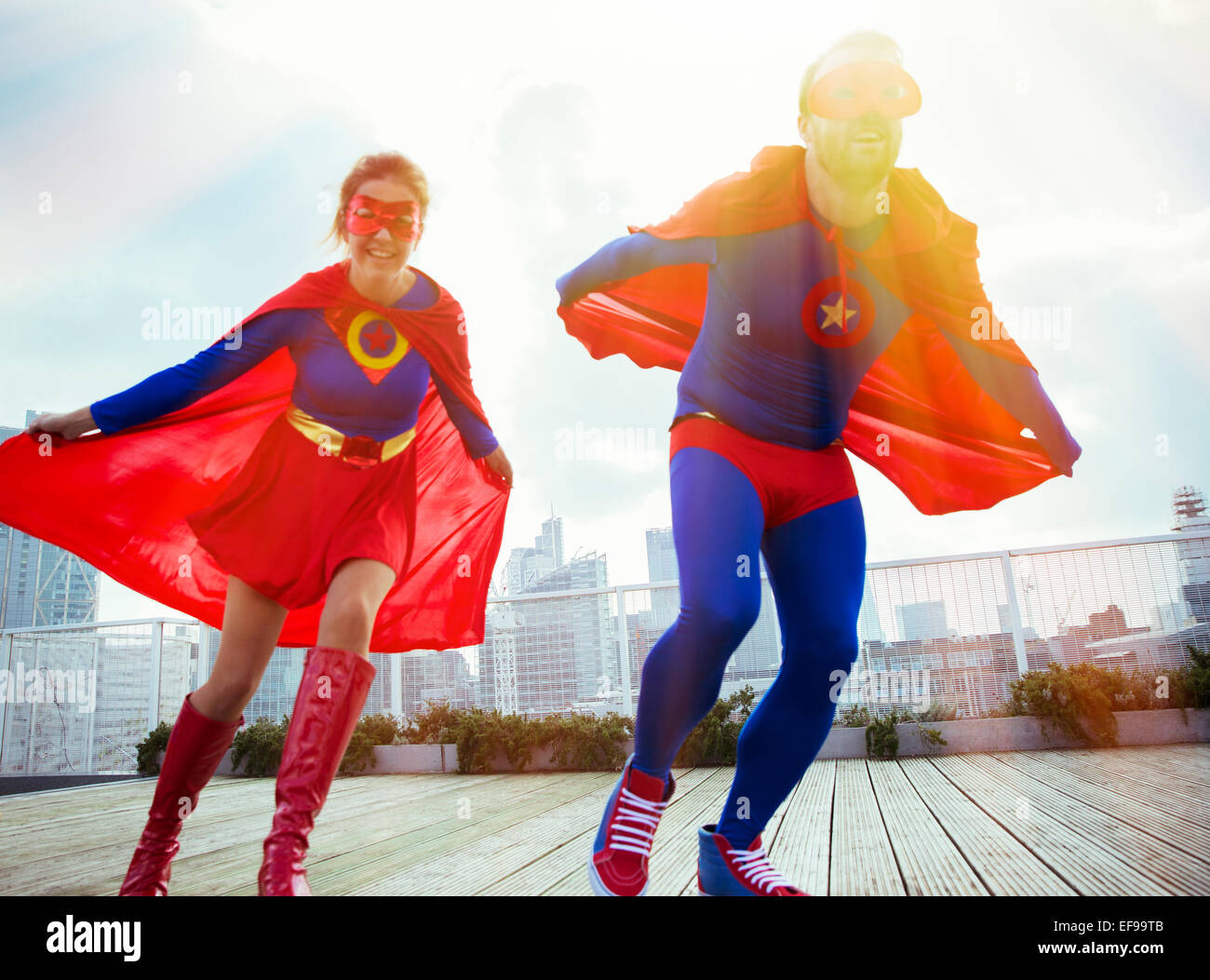 Superhéroes corriendo en la azotea de la ciudad Foto de stock