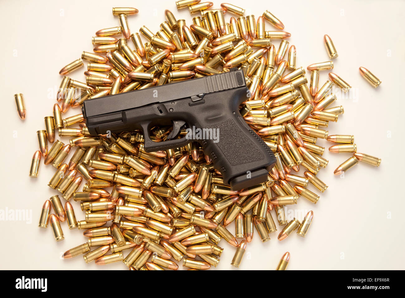 9mm Glock 19 pistola descansando sobre el montón de munición sobre fondo blanco. Foto de stock