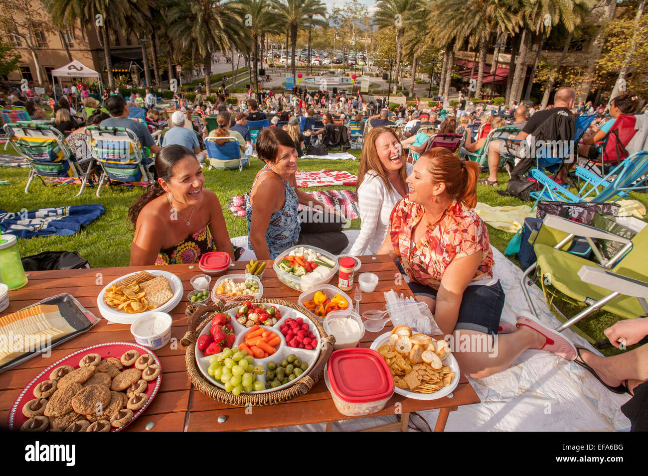 Las mujeres que asistían a un concierto al aire libre en un Aliso Viejo, CA, parque disfrutar de una cena tipo picnic. Foto de stock