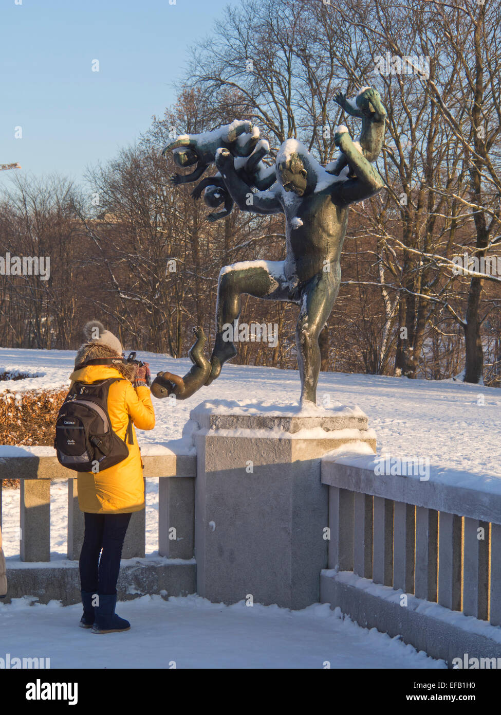 Invierno en Vigelandsparken, Oslo, Noruega, la nieve da a las esculturas un acabado especial, turista fotografiando macho de bronce Foto de stock
