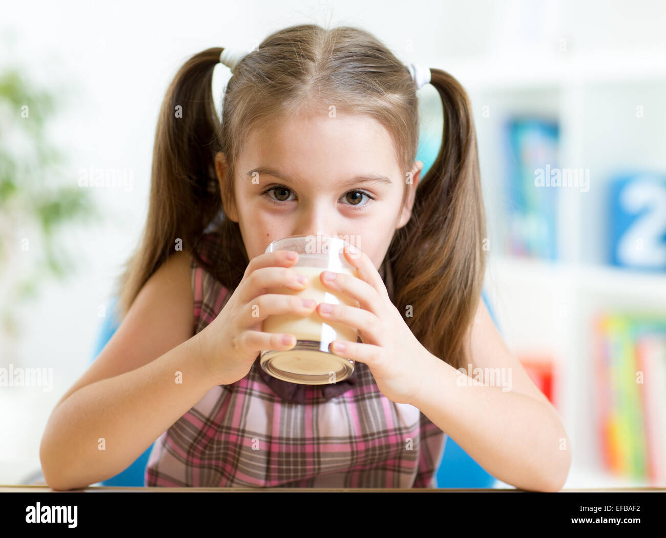 Niño bebiendo leche de vidrio Foto de stock