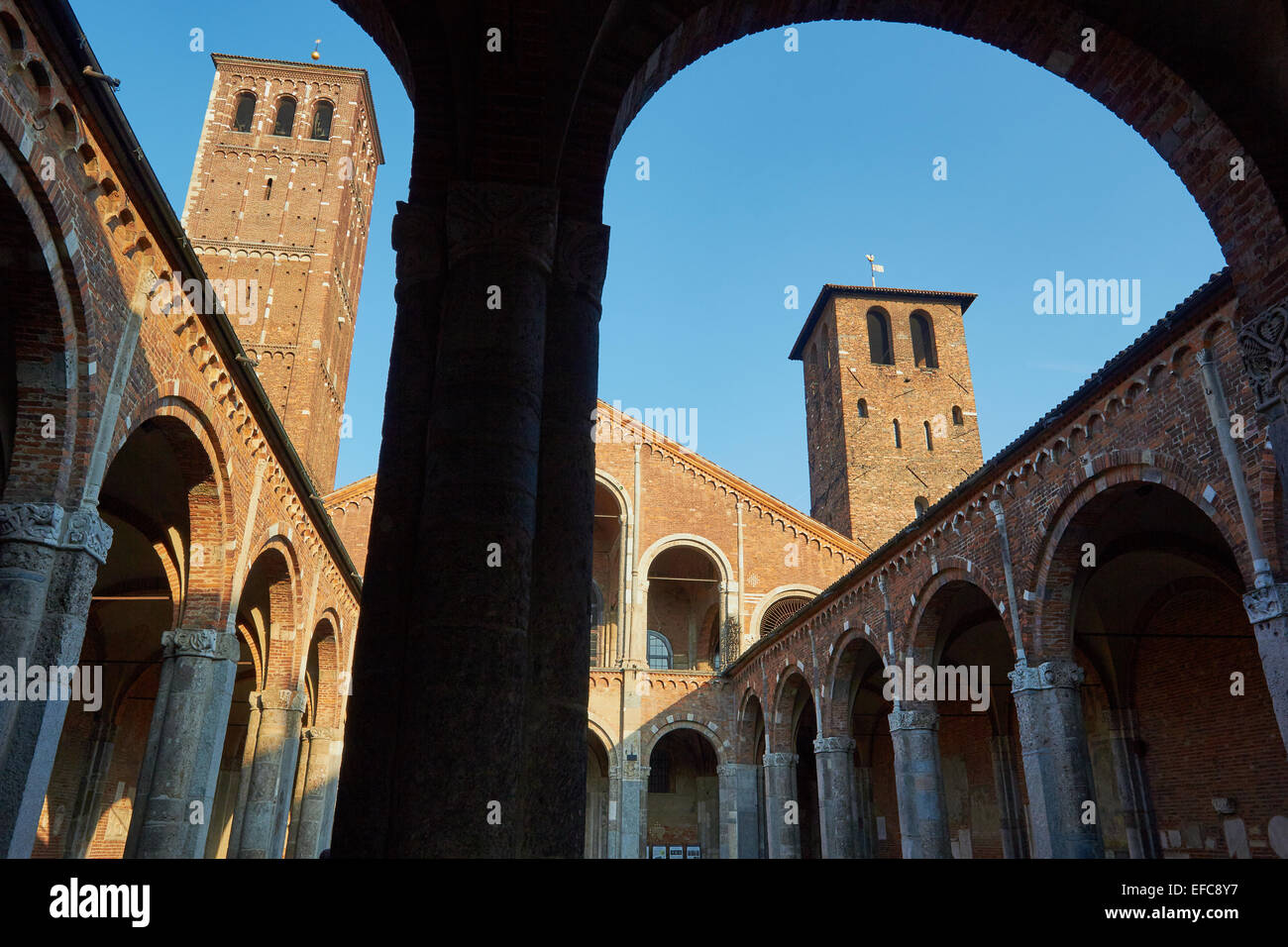 Entrada del patio abovedado y dos campanarios de iglesia de Sant'Ambrogio Milan Italia Europa Foto de stock