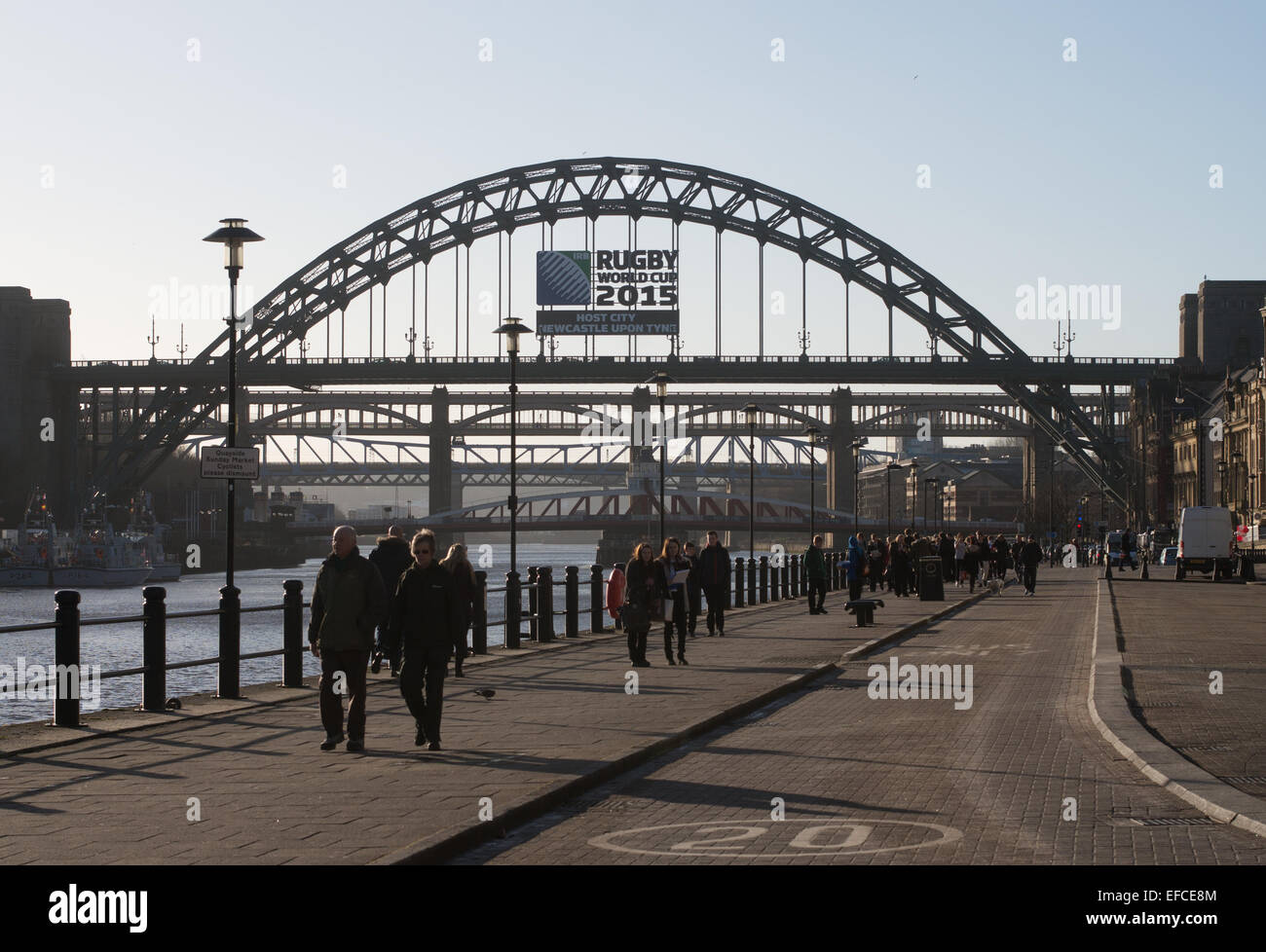 La gente caminando a lo largo de Newcastle Quayside, con los puentes Tyne en el fondo, Newcastle upon Tyne, Inglaterra, Reino Unido. Foto de stock