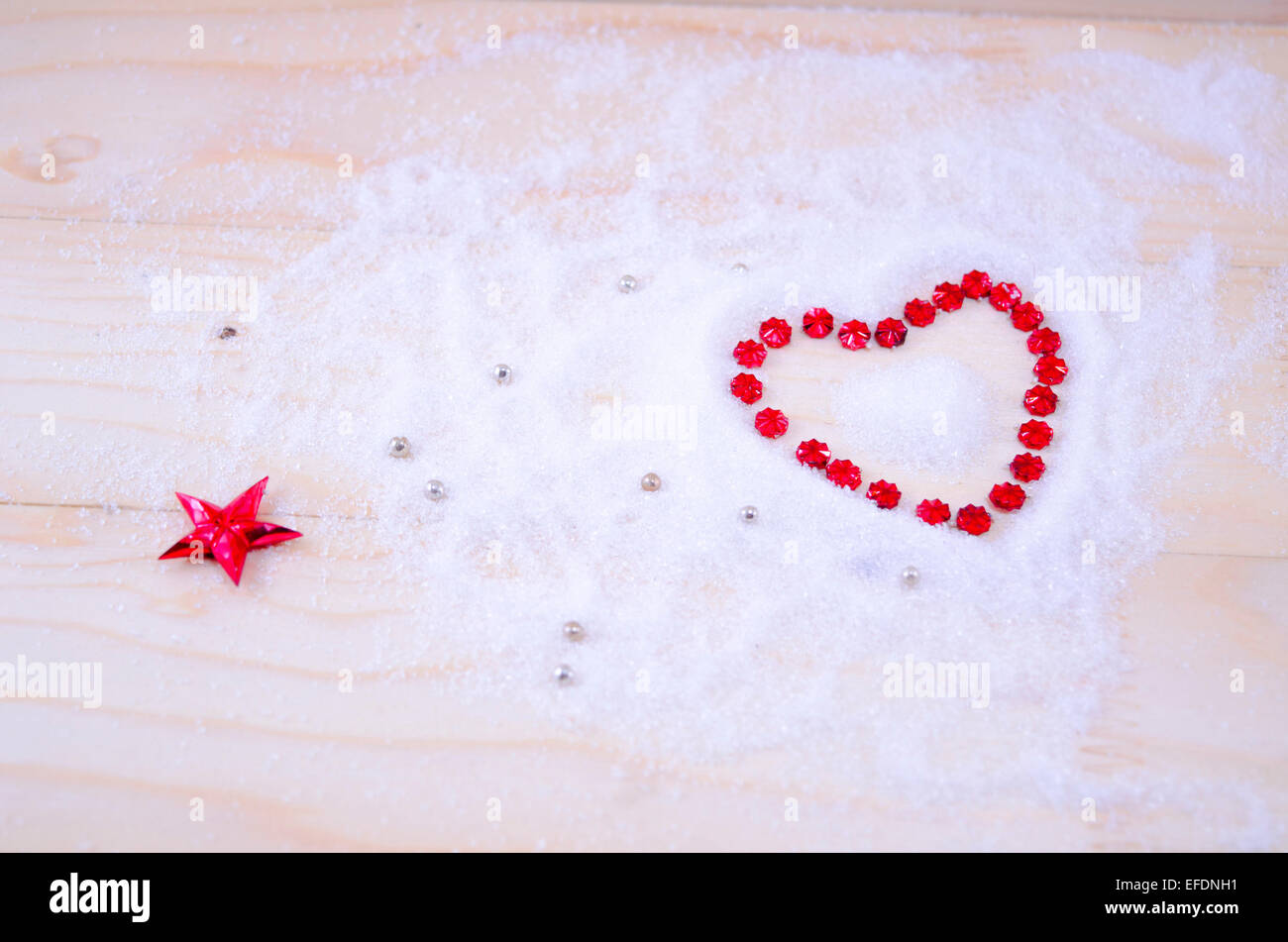 Con forma de corazón de estrella roja ornamentos en polvo blanco Foto de stock