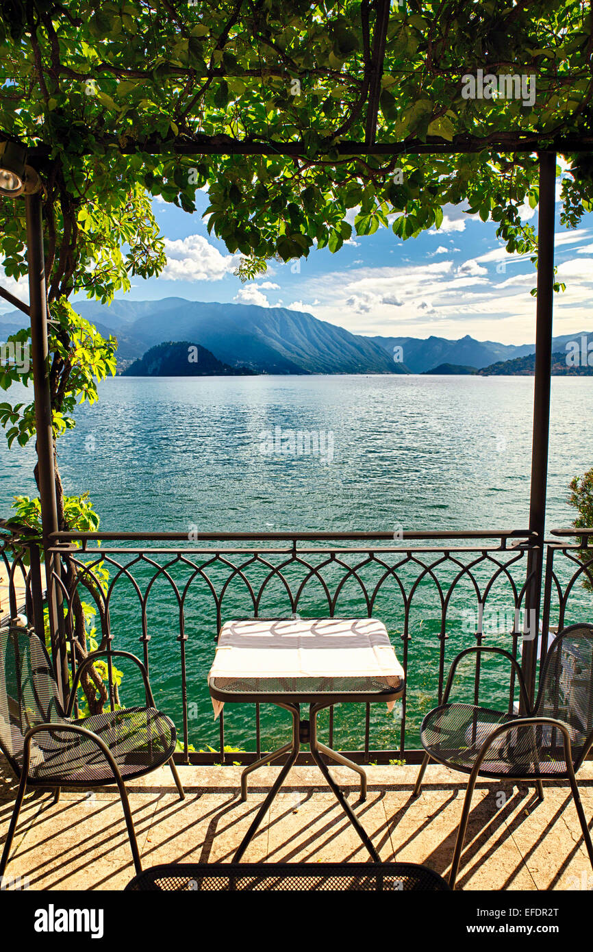Vista de una pequeña mesa bajo una pérgola con vista al lago, Varenna, el Lago de Como, en Lombardía, Italia Foto de stock
