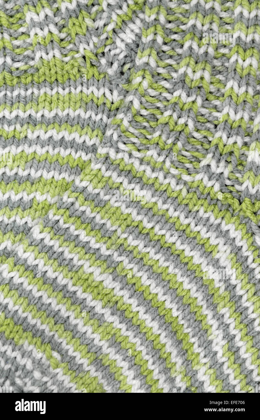 Cerca de dos verdes, grises y blancas rayas moteadas y calcetines de lana tejida, full frame, vertical Foto de stock