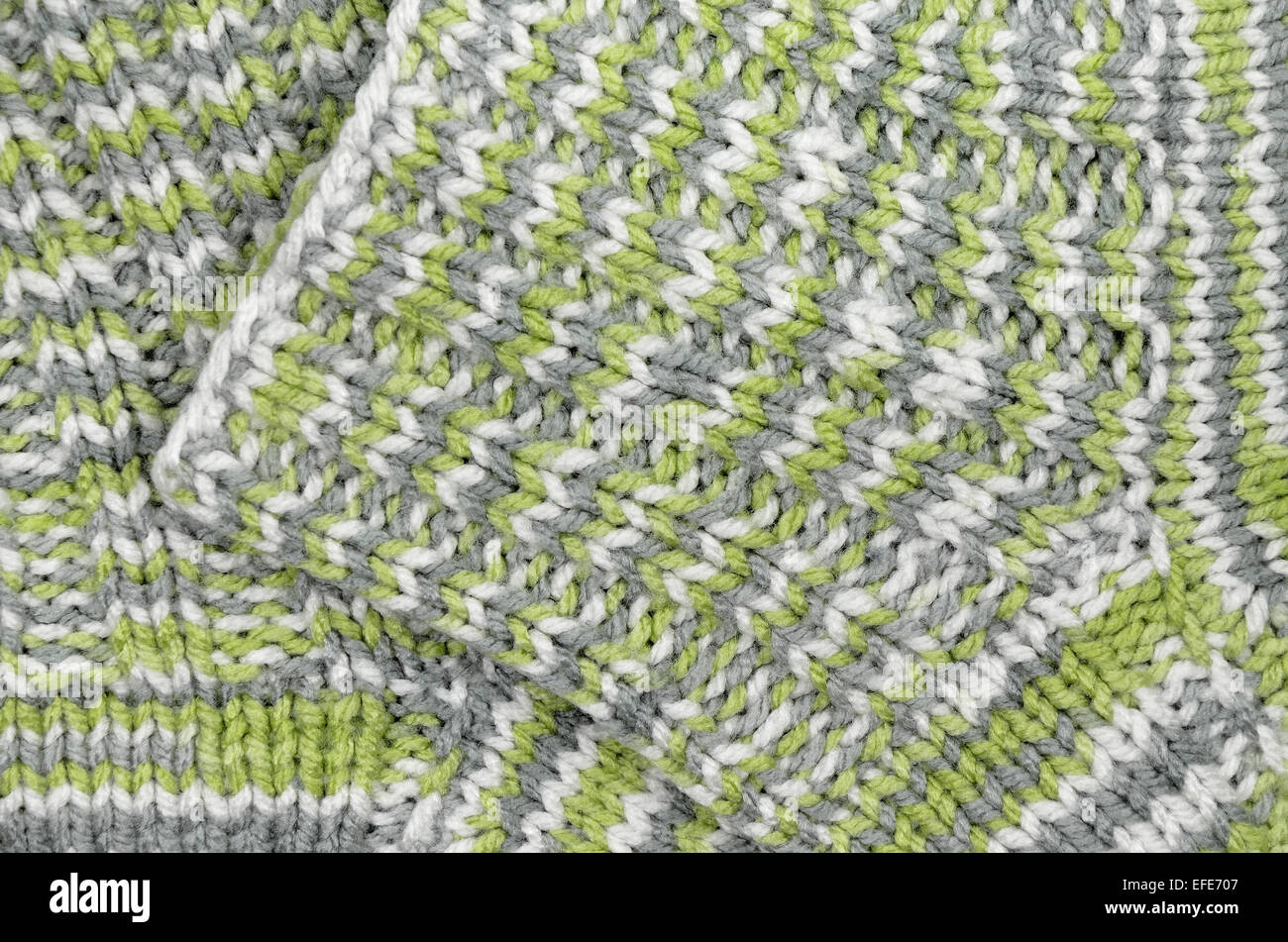 Cerca de dos verdes, grises y blancas rayas moteadas y calcetines de lana tejida, full frame Foto de stock
